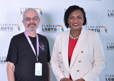 A pair of guests photographed at a sponsor branded backdrop in Orlando