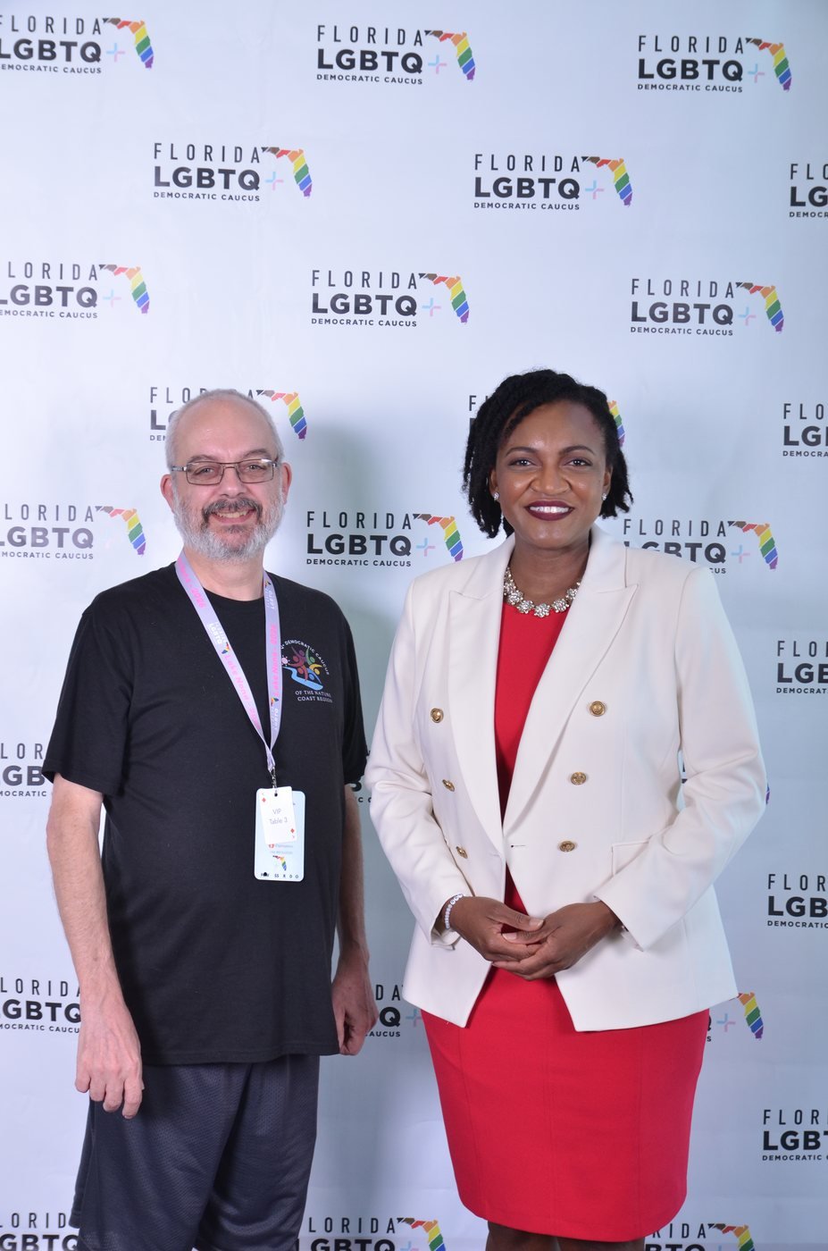 A pair of guests photographed at a sponsor branded backdrop in Orlando