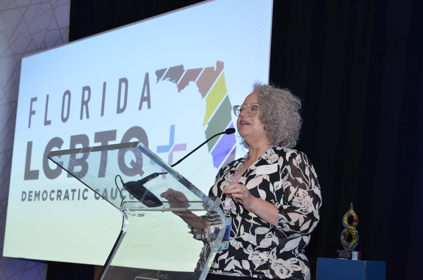 Speaker at the podium with event branding projected behind, Lake Nona, Orlando