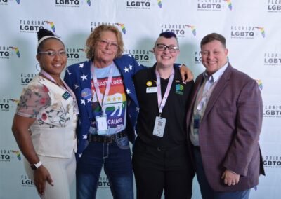 Four guests photographed together at a branded step-and-repeat backdrop in Orlando