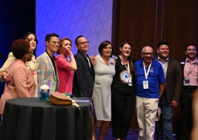 A large group gathered on stage at the close of a corporate programme in Orlando