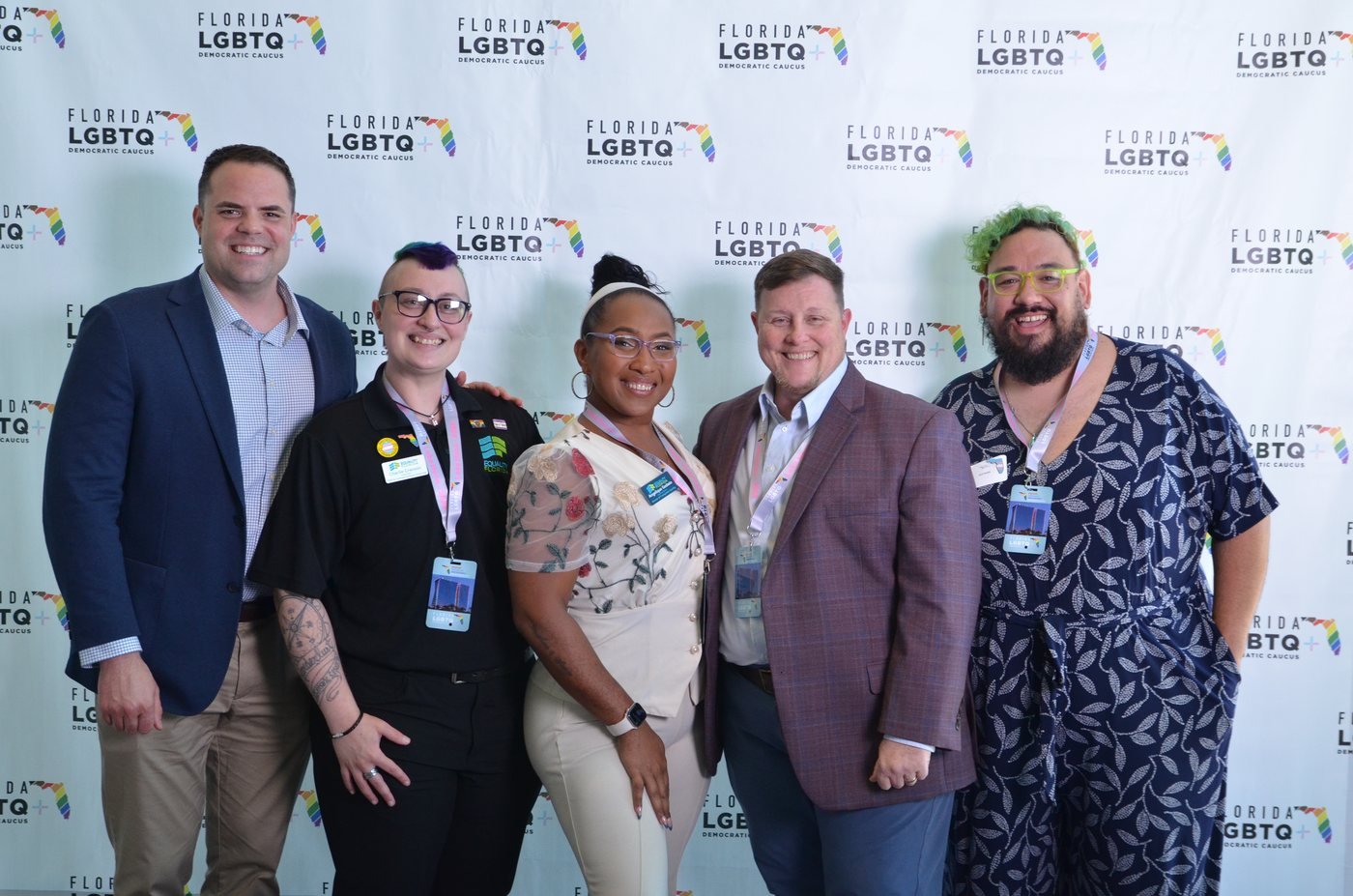 Five guests photographed together at a branded step-and-repeat backdrop in Orlando