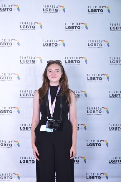 A single guest photographed at a branded event backdrop