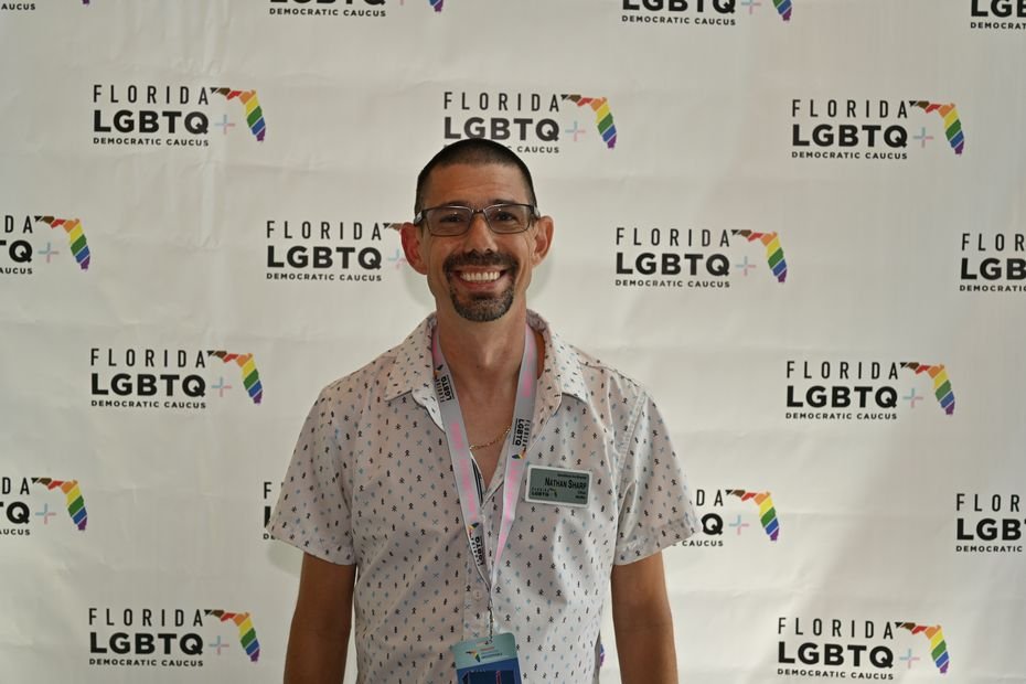 A guest photographed alone at a branded conference backdrop