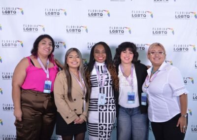 Five guests photographed as a group at a branded backdrop