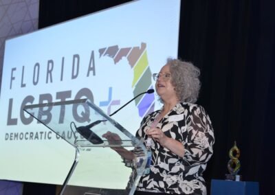 A speaker at the podium with the event branding projected behind