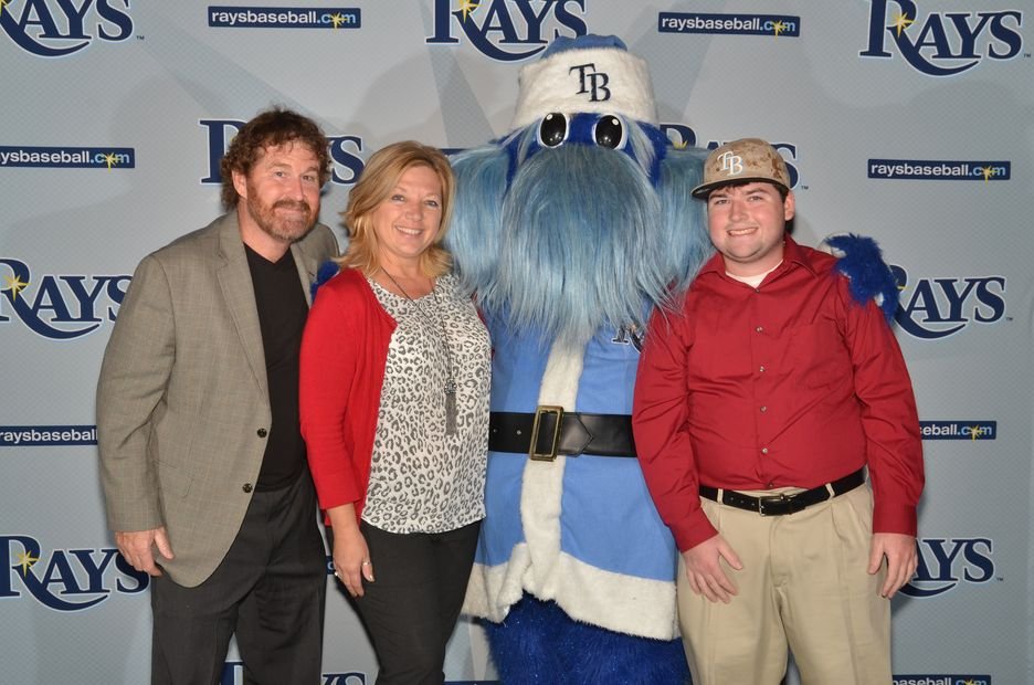Guests photographed with a team mascot at a sponsor activation