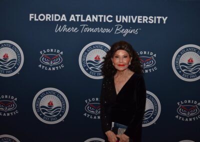 A guest in black tie photographed at the Florida Atlantic University gala backdrop at The Boca Raton