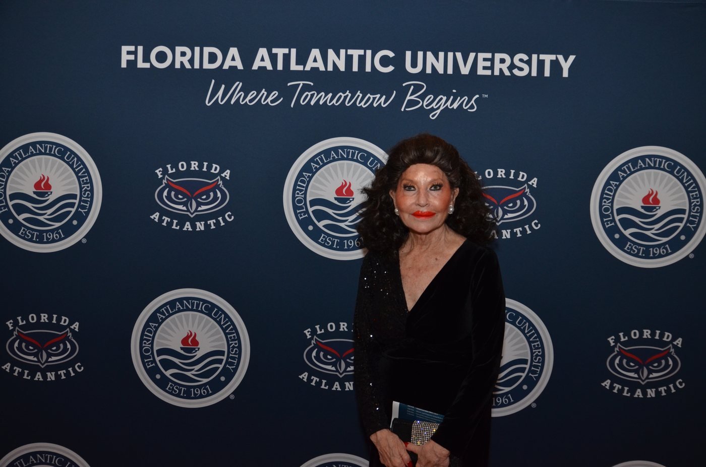 A guest in black tie photographed at the Florida Atlantic University gala backdrop at The Boca Raton